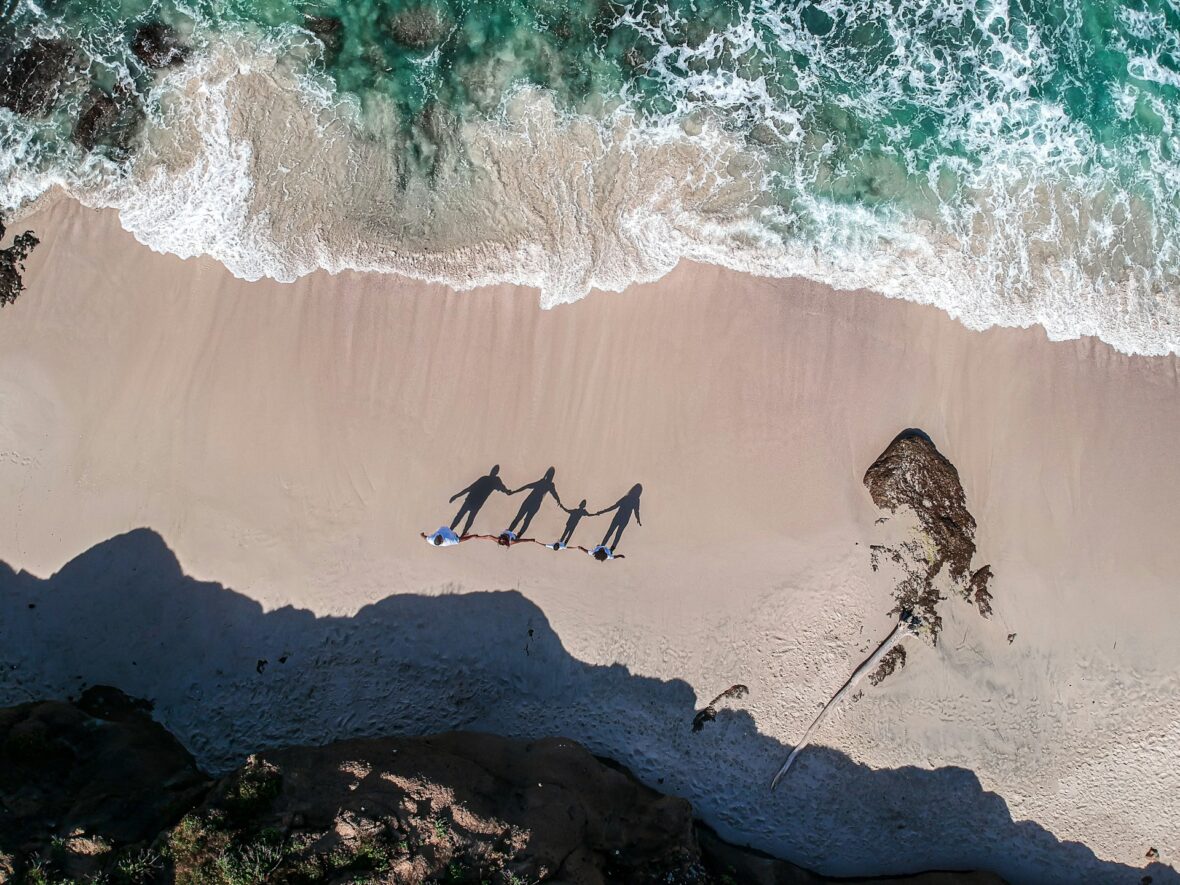 a-group-of-people-standing-on-top-of-a-sandy-beach